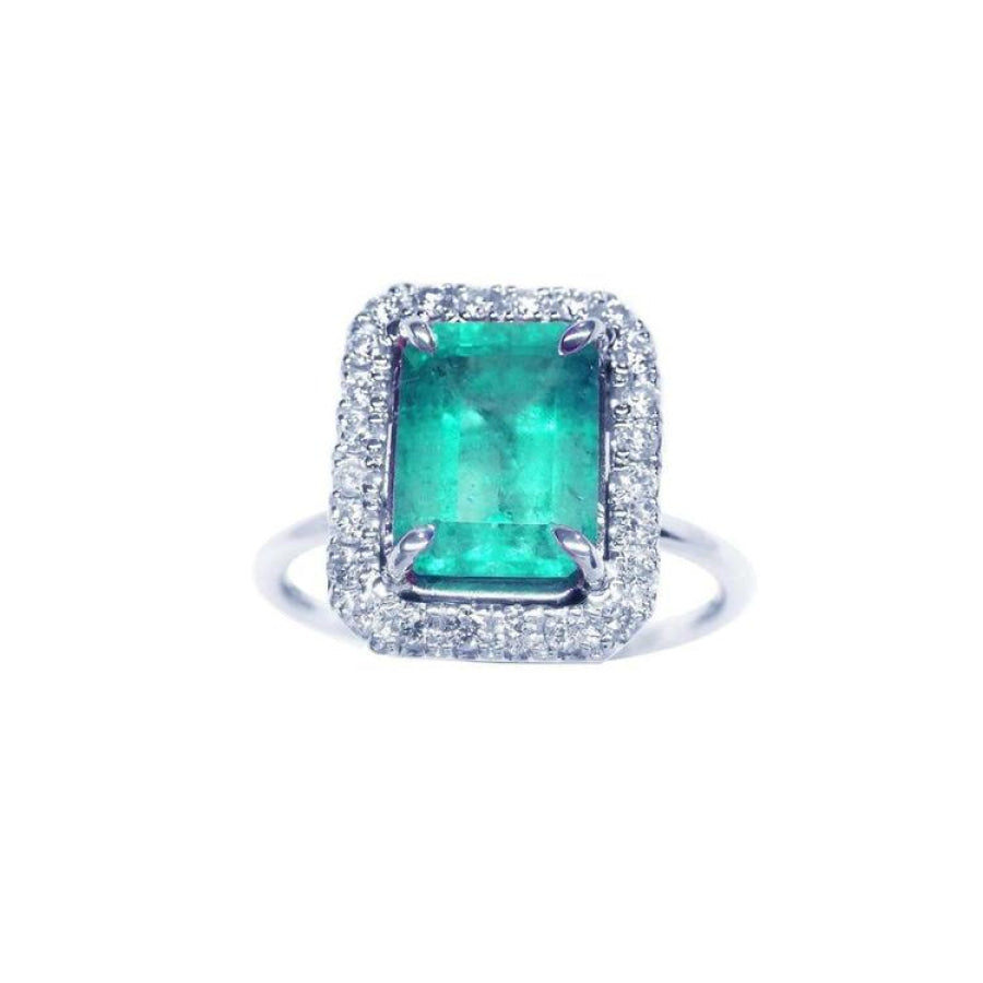 A square emerald-cut emerald ring for women encircled by a halo diamond in 18k white gold.