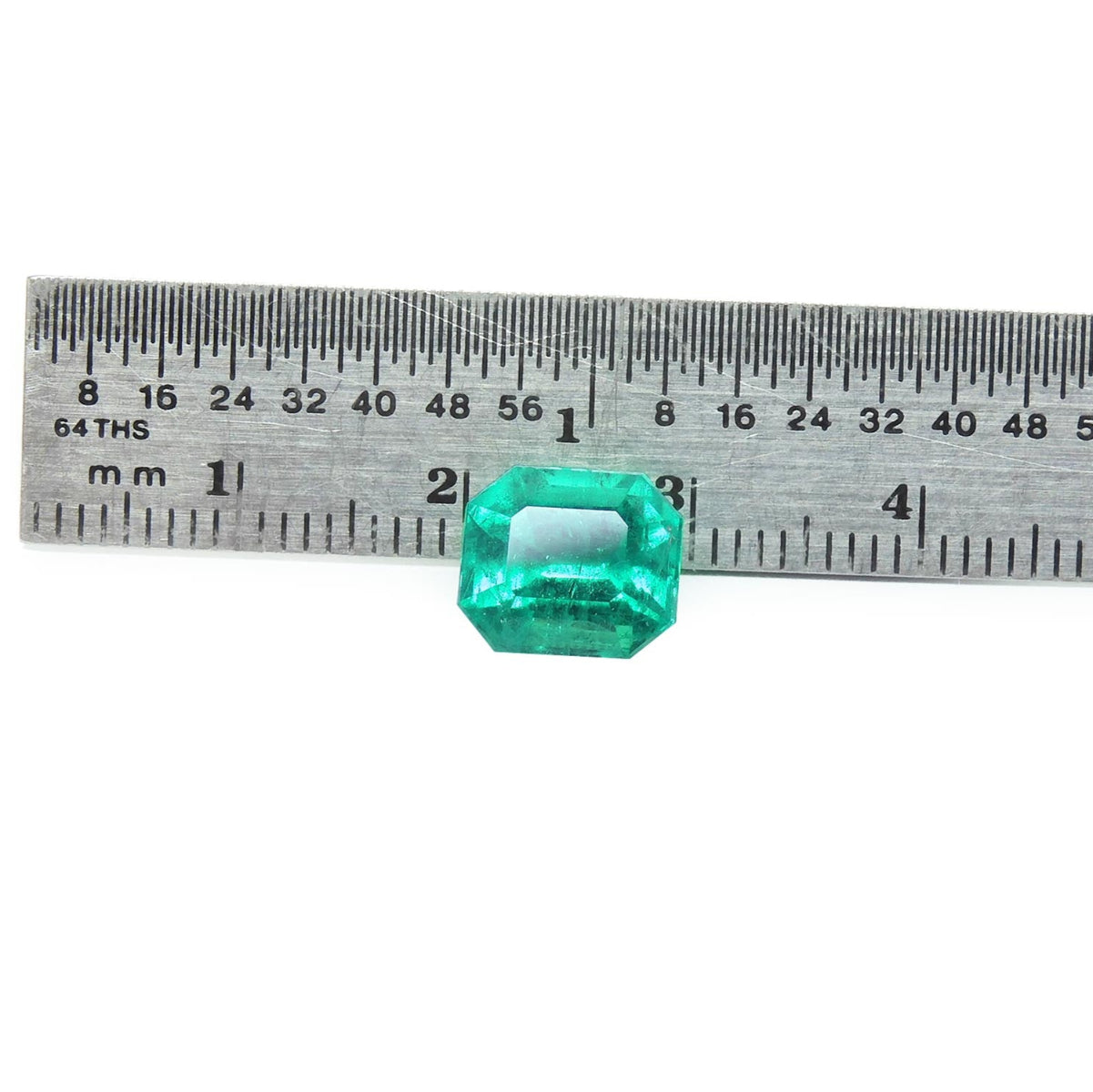 Natural loose emerald Muzo Colombia fine quality, front side table and crown visibles with a ruler measurer