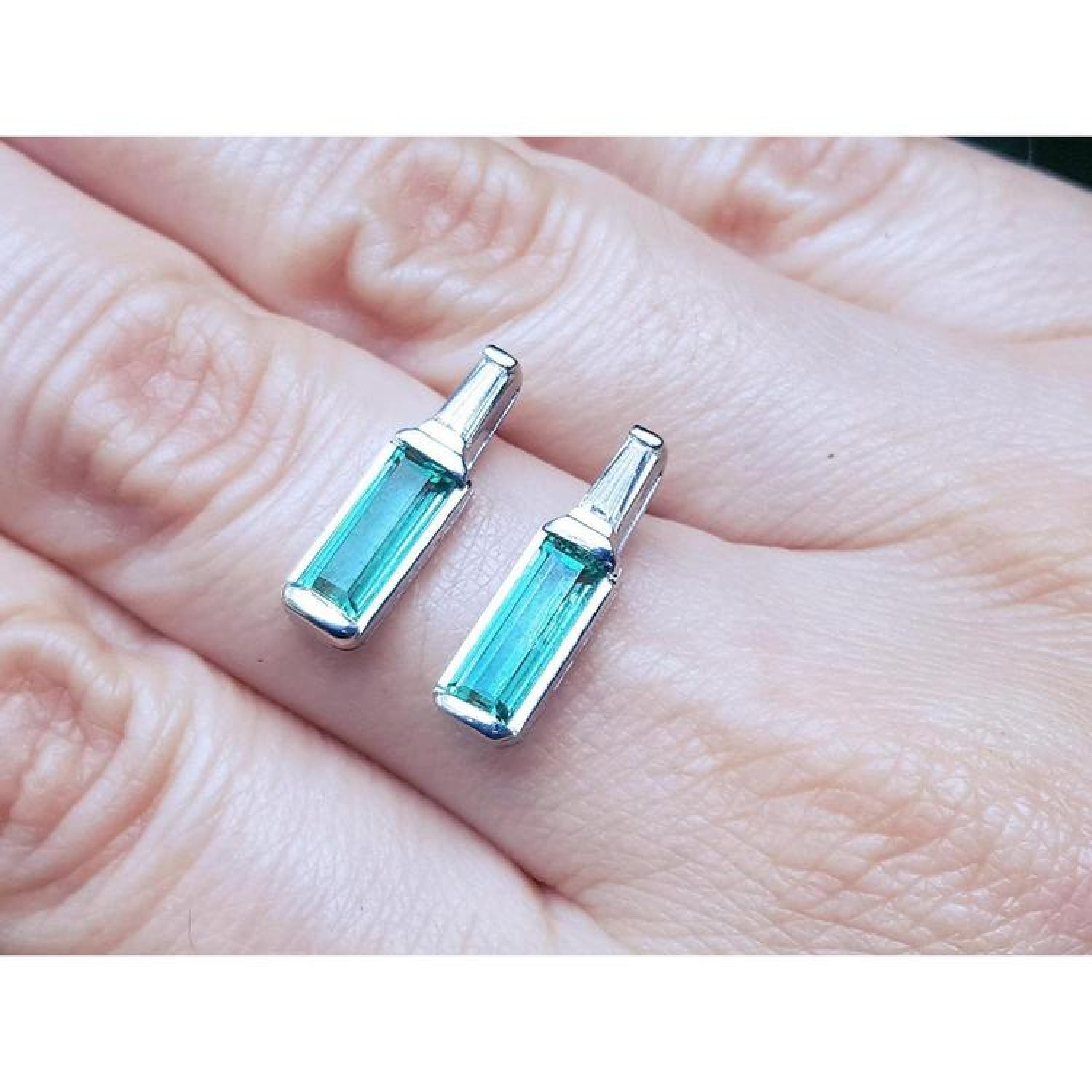 2.00 ct natural baguette emerald stud earrings in 14k white gold with diamond accents.