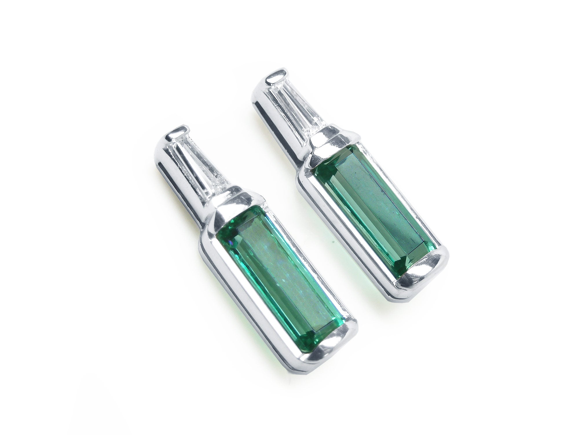 Two baguette cut emerald stud earrings with tapered baguette diamonds on top, white gold.