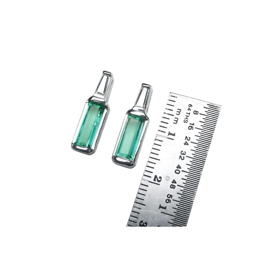 2.00 ct. natural baguette emerald stud earrings in 14k white gold with tapered baguette diamonds.