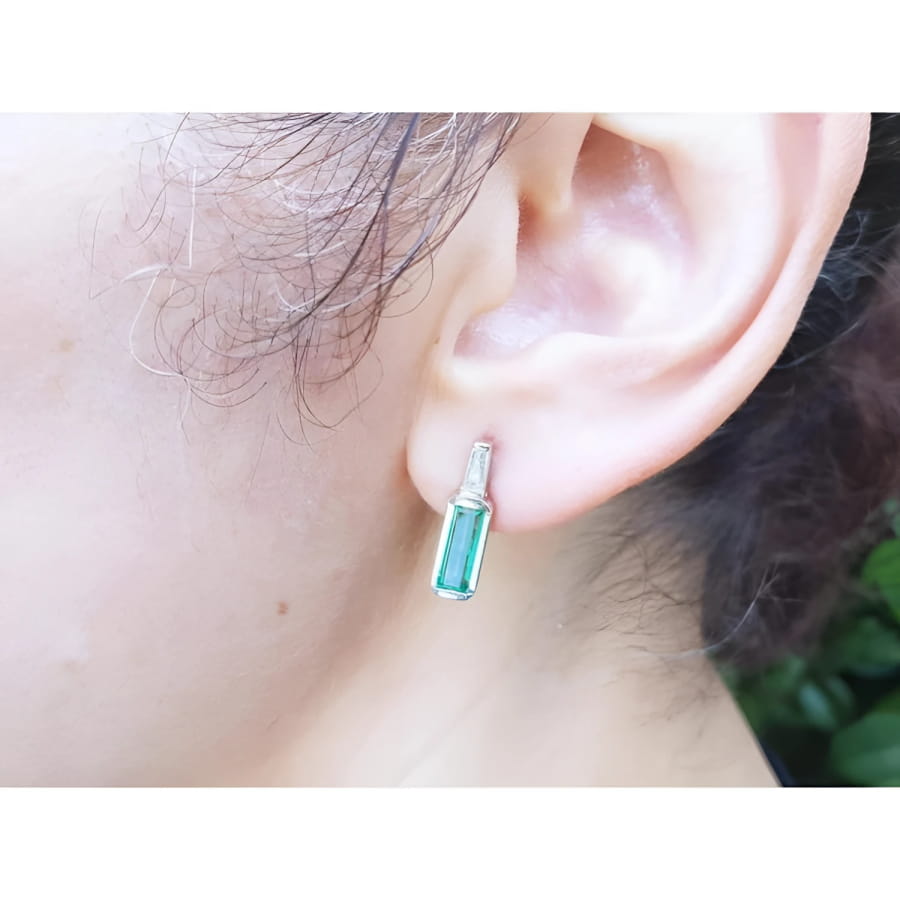 2.00 ct. natural baguette emerald stud earrings in 14k white gold, featuring a medium green emerald and diamond accent.