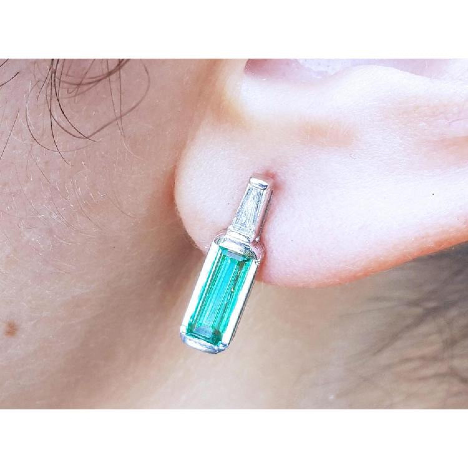 14k white gold stud earring with a baguette emerald and diamond accent, shaped like a miniature bottle.