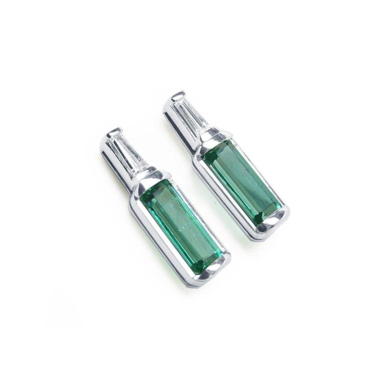 A pair of baguette cut natural emerald stud earrings with tapered baguette diamonds on top, 14k white gold.