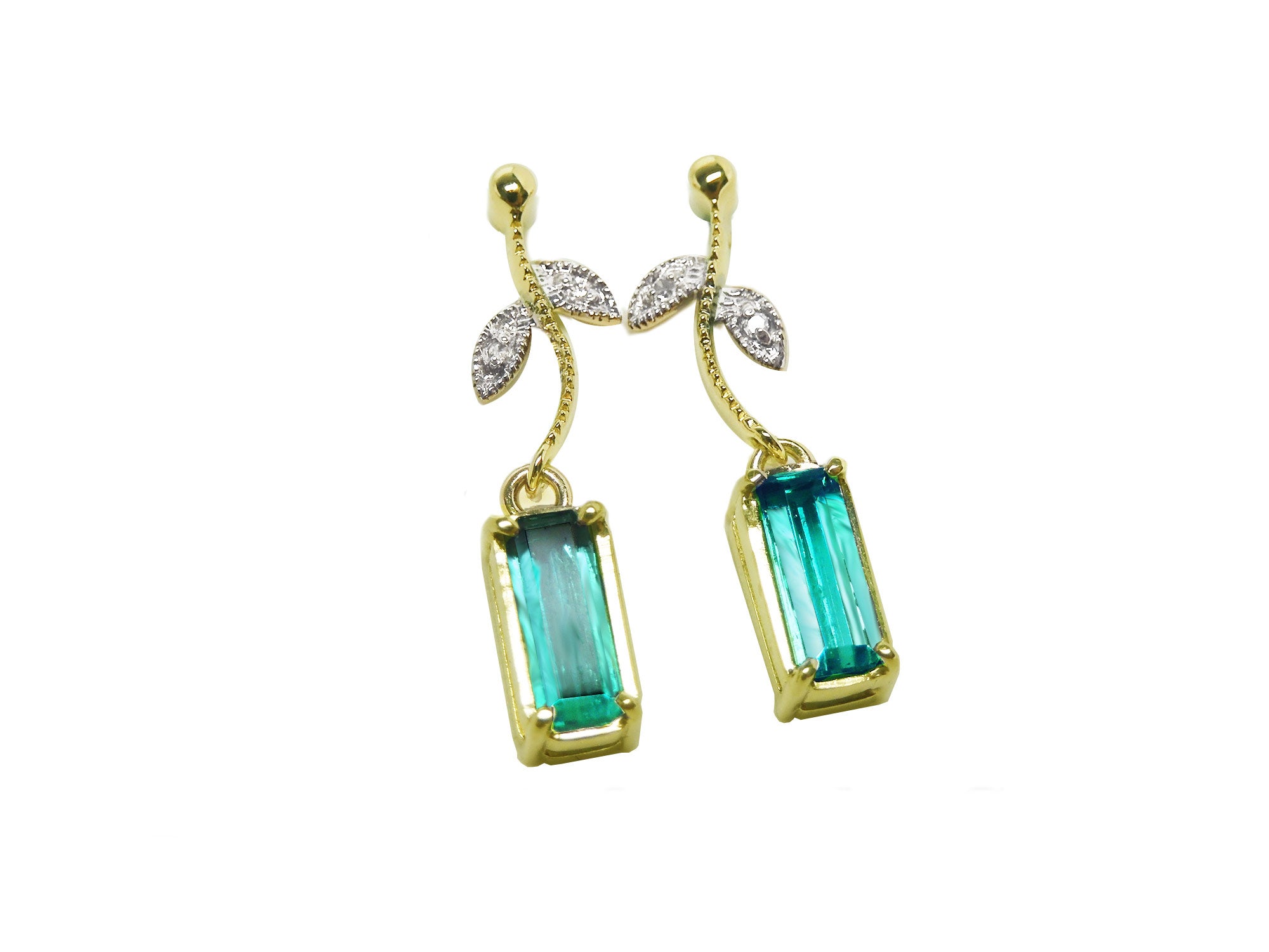 Front position of a pair of emerald dangle earrings in 14k yellow gold, pending from a leafy stem
