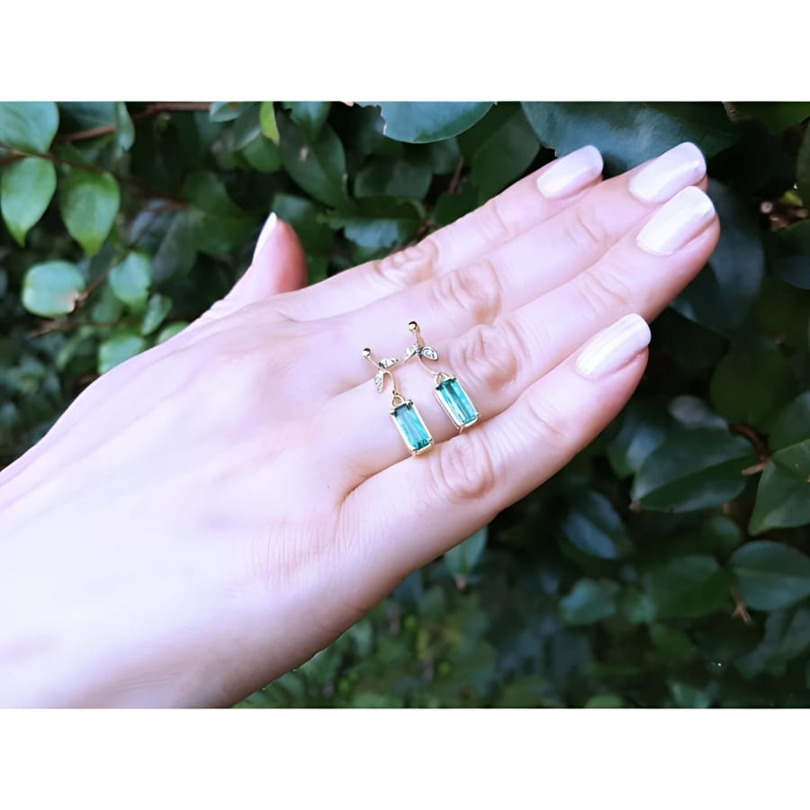 14K gold stud emerald leaf earrings with vibrant rectangular green emeralds and diamonds.
