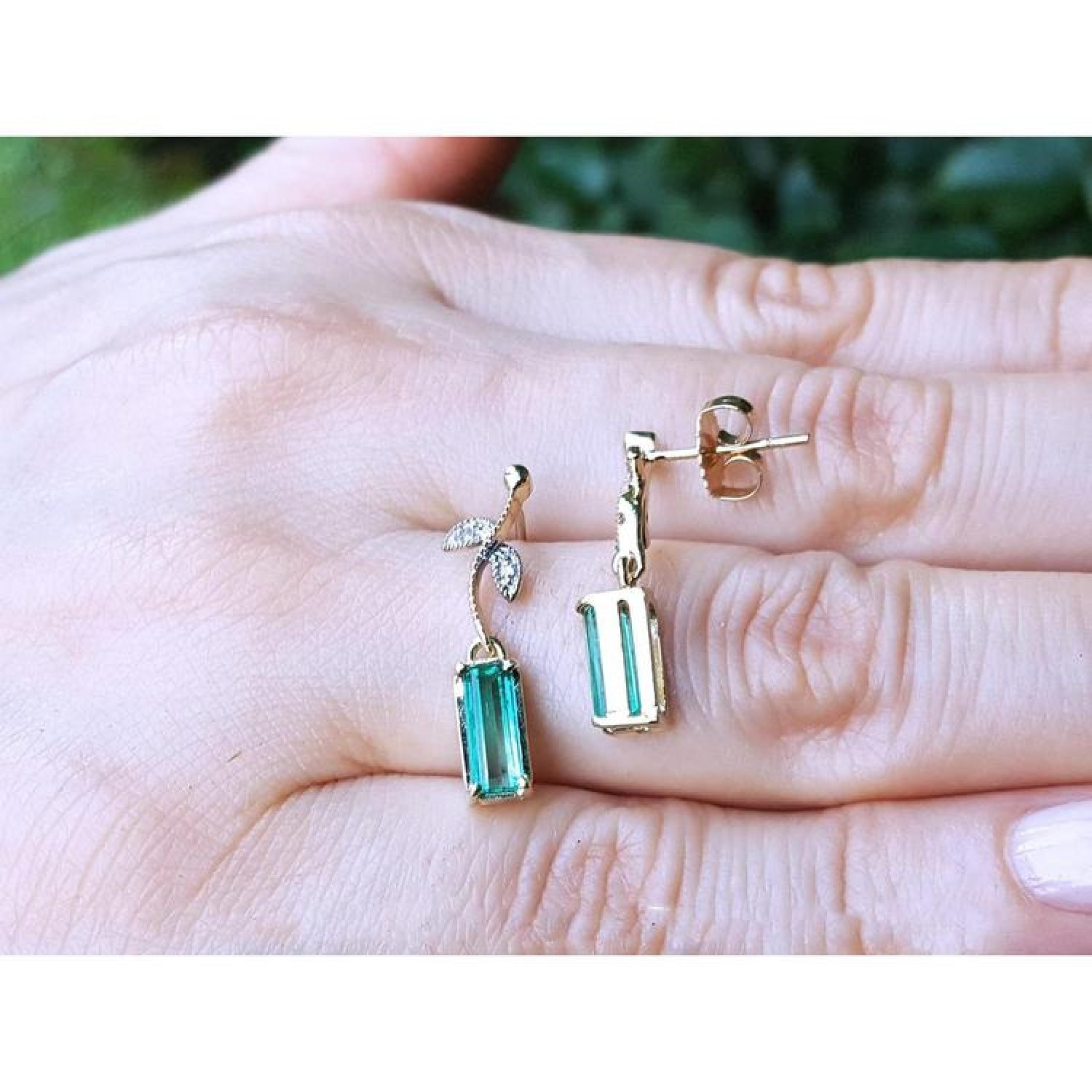 14K gold stud emerald leaf earrings with vibrant medium green rectangular emeralds and diamond accents.
