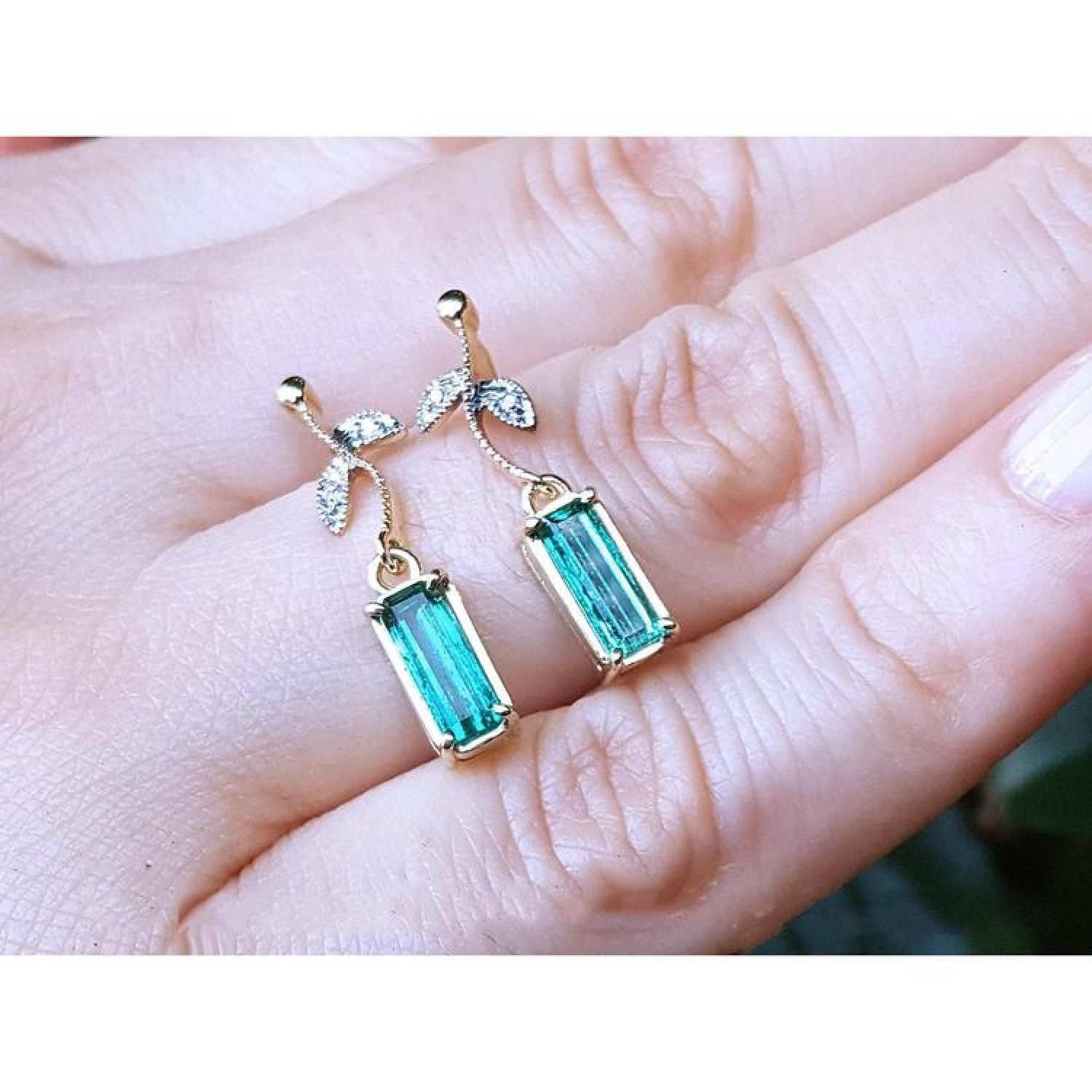 14K gold stud emerald leaf earrings with vibrant rectangular Colombian emeralds and diamonds.