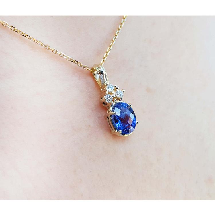 14K yellow gold pendant with oval tanzanite and three diamonds on a delicate chain.
