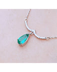USA made women's necklace natural Colombian emerald dangling from a wavy central bar with diamonds pave set in 14k white gold