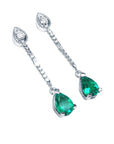 Pair of teardrop emerald dangle earrings on a right-side position top view.