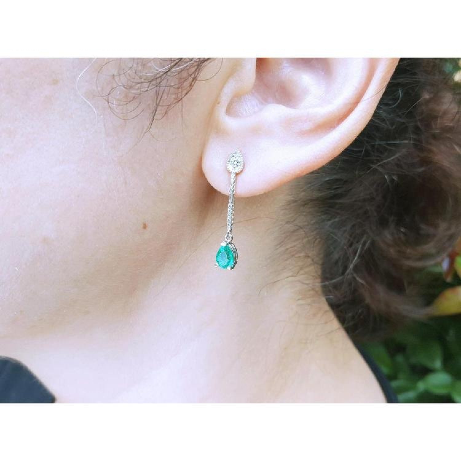 Emerald dangle earrings with pear-shaped Muzo emeralds and diamonds in 14K white gold.