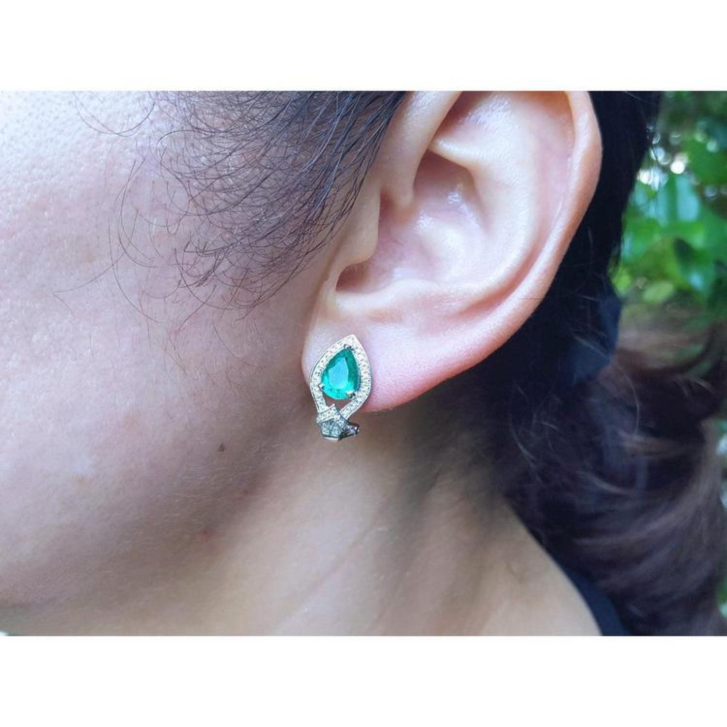 14K gold clip/post earring with a pear-shaped Colombian emerald and diamond accents on an ear.