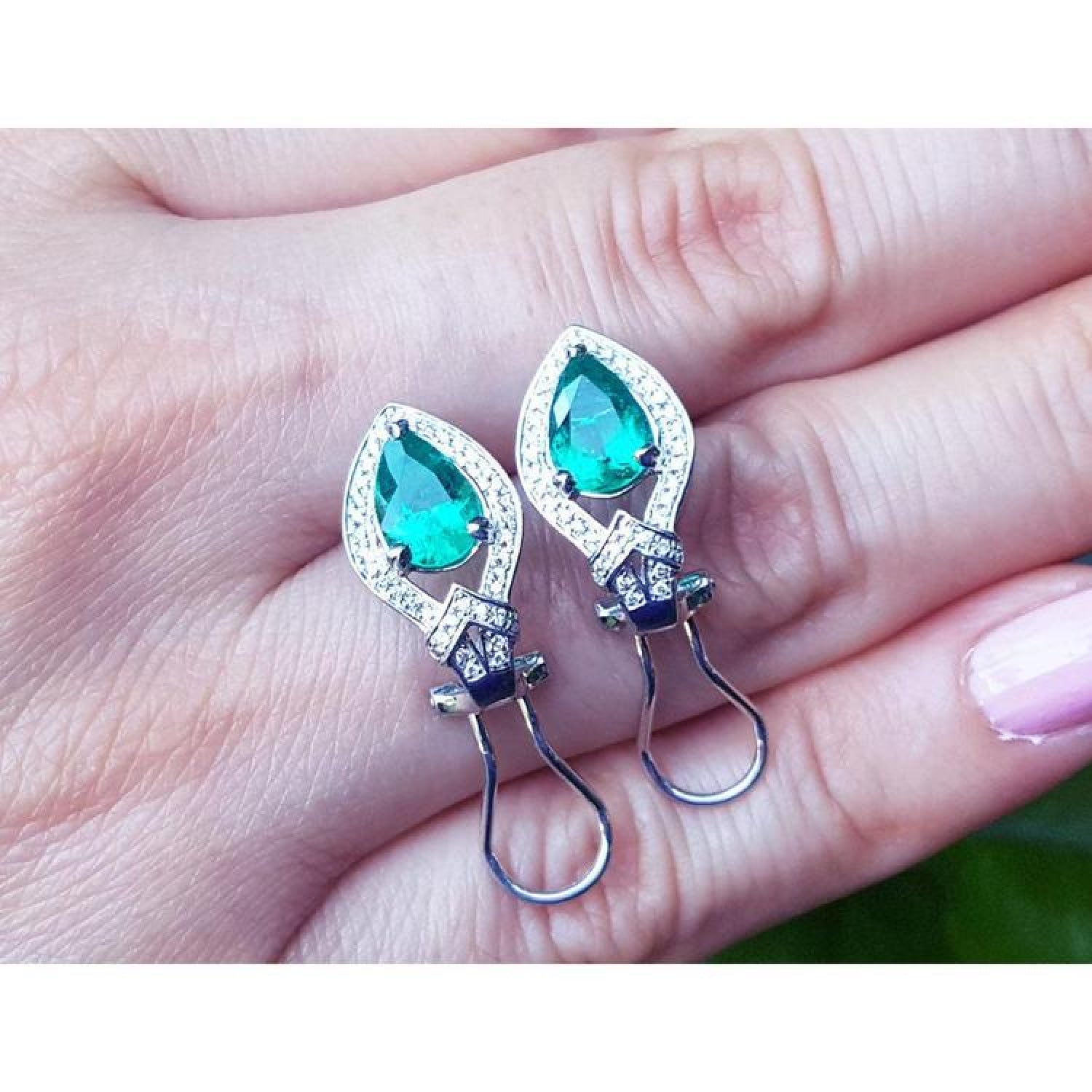 14K white gold clip/post earrings with pear-shaped Colombian emeralds and diamond accents.