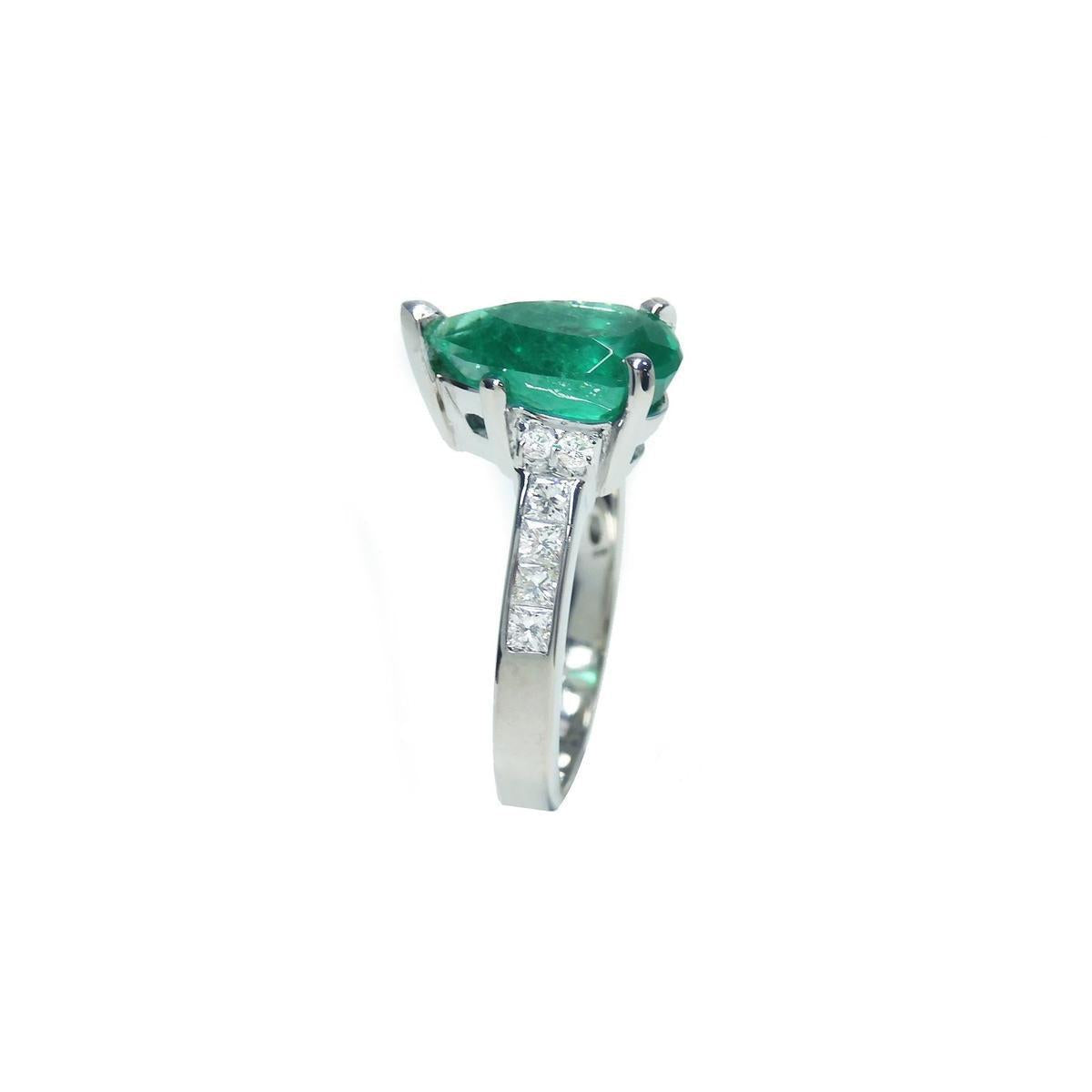 This teardrop emerald ring displays its left side profile from the top to down band view.