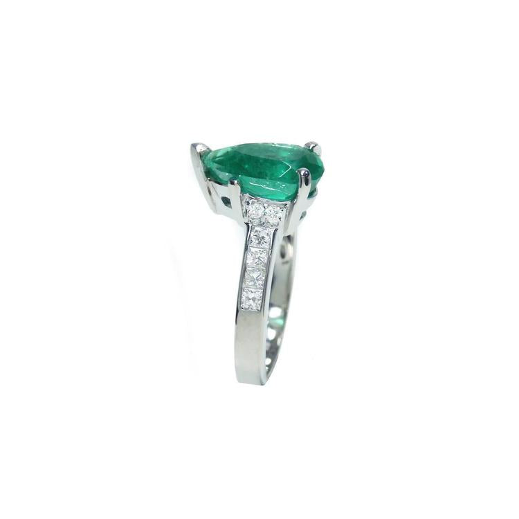 3.09 ct. pear-shaped deep green emerald ring with princess cut diamonds in 14K white gold.