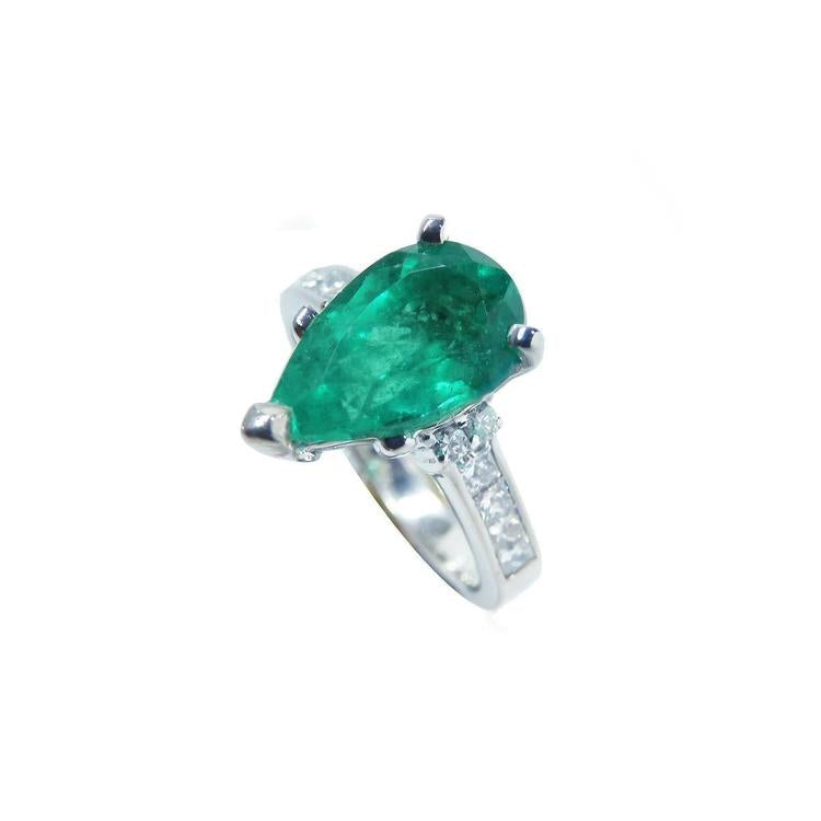 Pear-shaped deep green emerald ring with princess cut diamonds in 14K white gold.