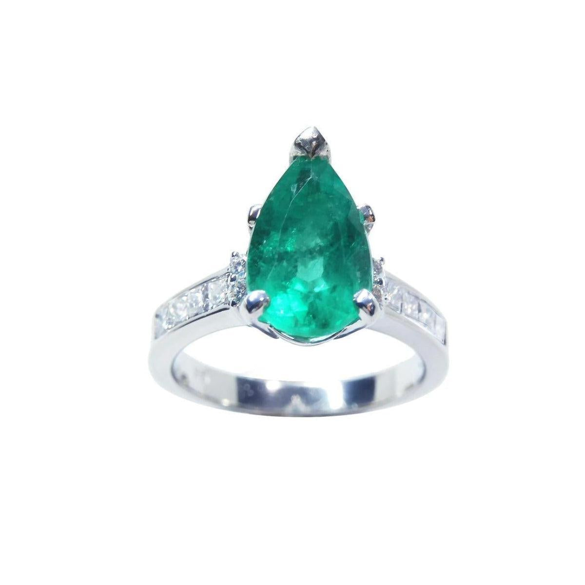 A topside view of a teardrop emerald ring white gold with accent diamonds.