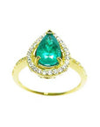 The top view of a ring with a teardrop emerald encircled by a halo diamond in 14k yellow gold.