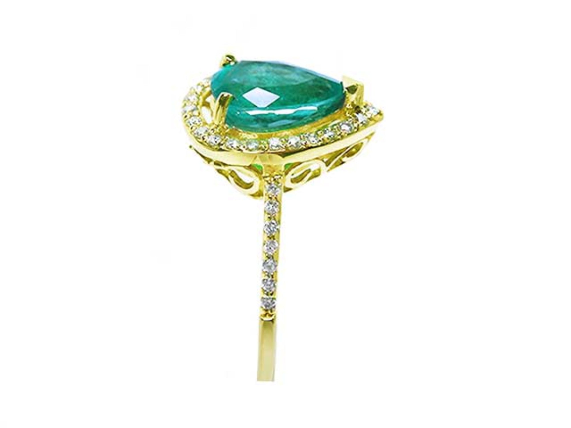 Side profile of a pear cut emerald with diamonds around, gallery and band ring in yellow gold.