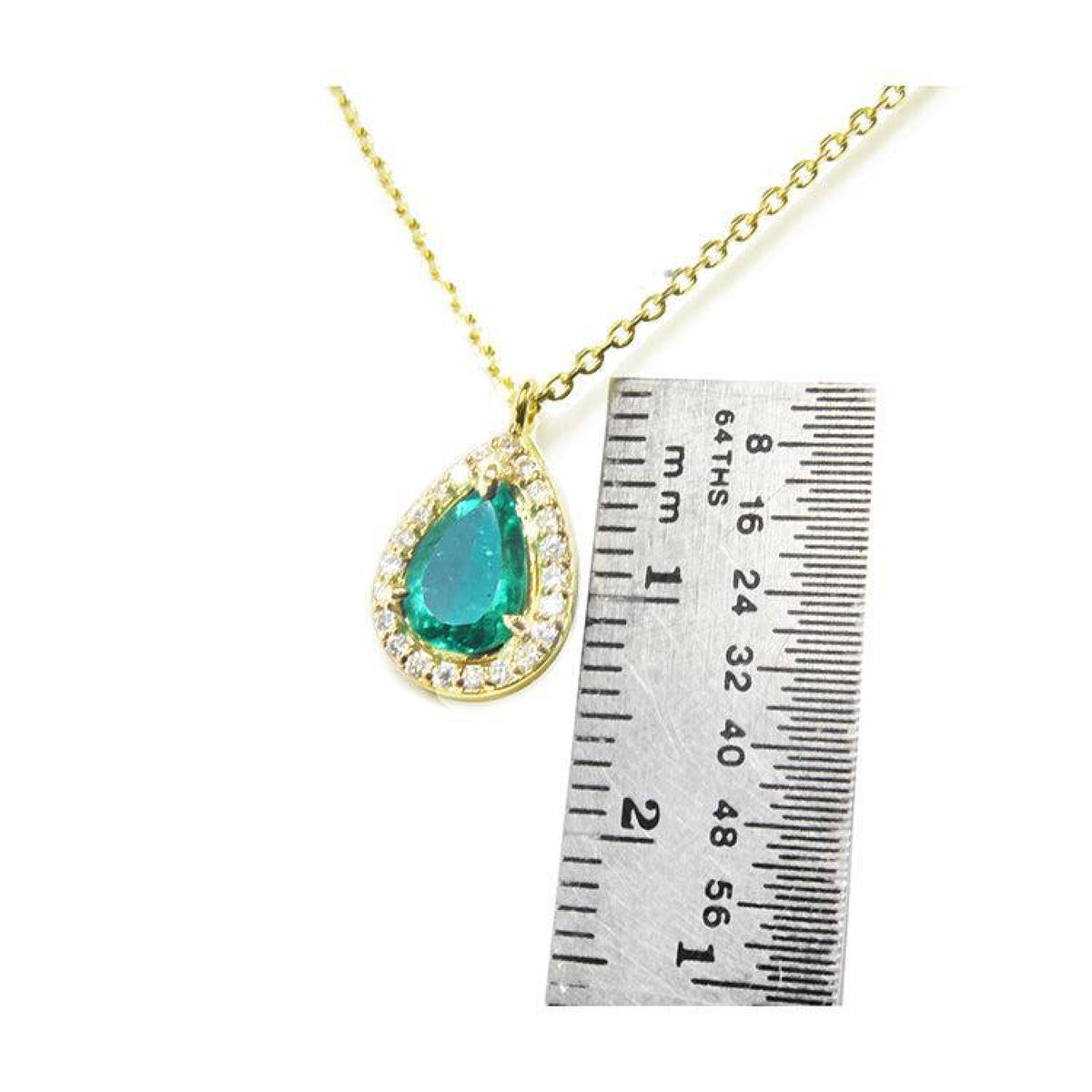 Pear-shaped natural emerald necklace with diamond halo in 14K yellow gold, shown next to a ruler.