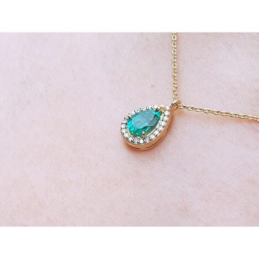 Pear-shaped natural emerald necklace with diamond halo on 14K yellow gold chain.