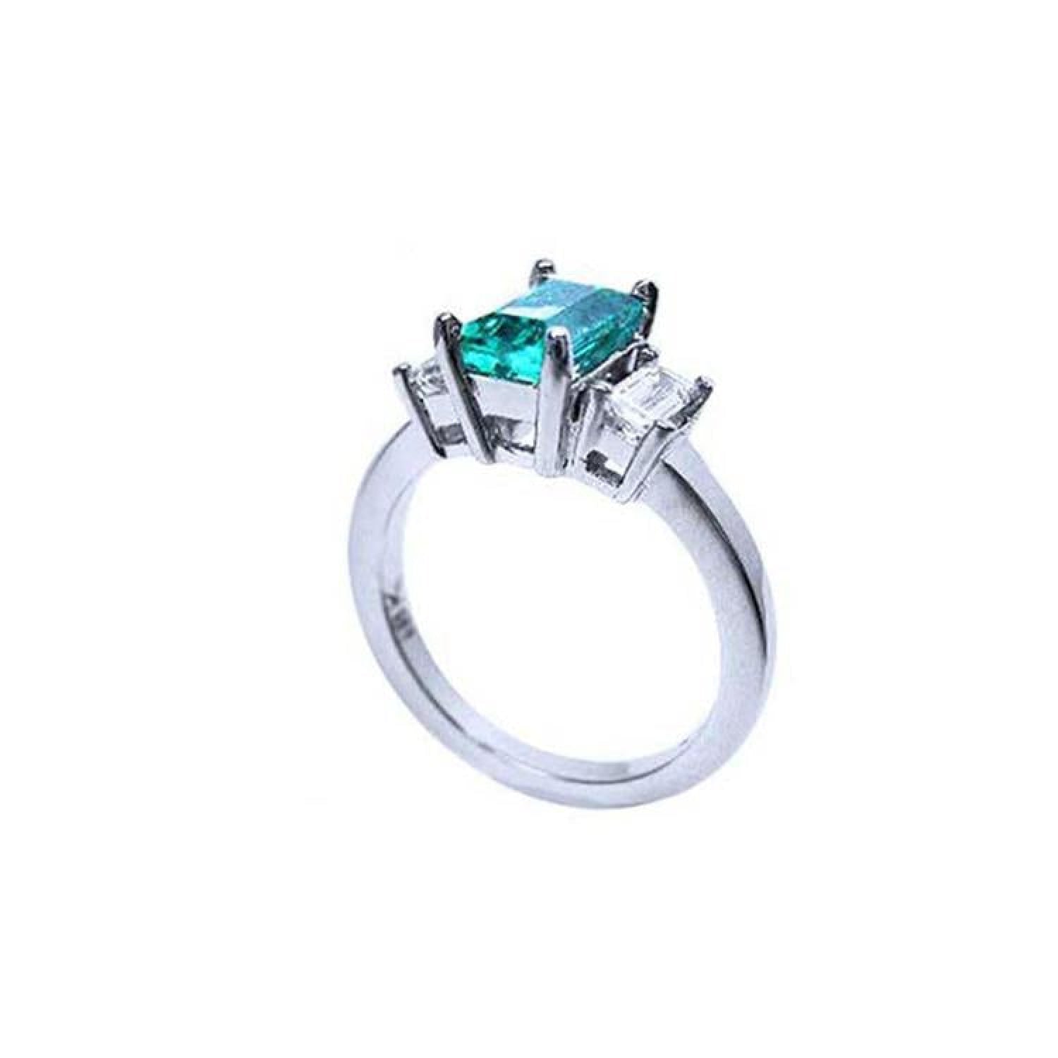 18K white gold three-stone ring with a rectangular emerald and two baguette diamonds.