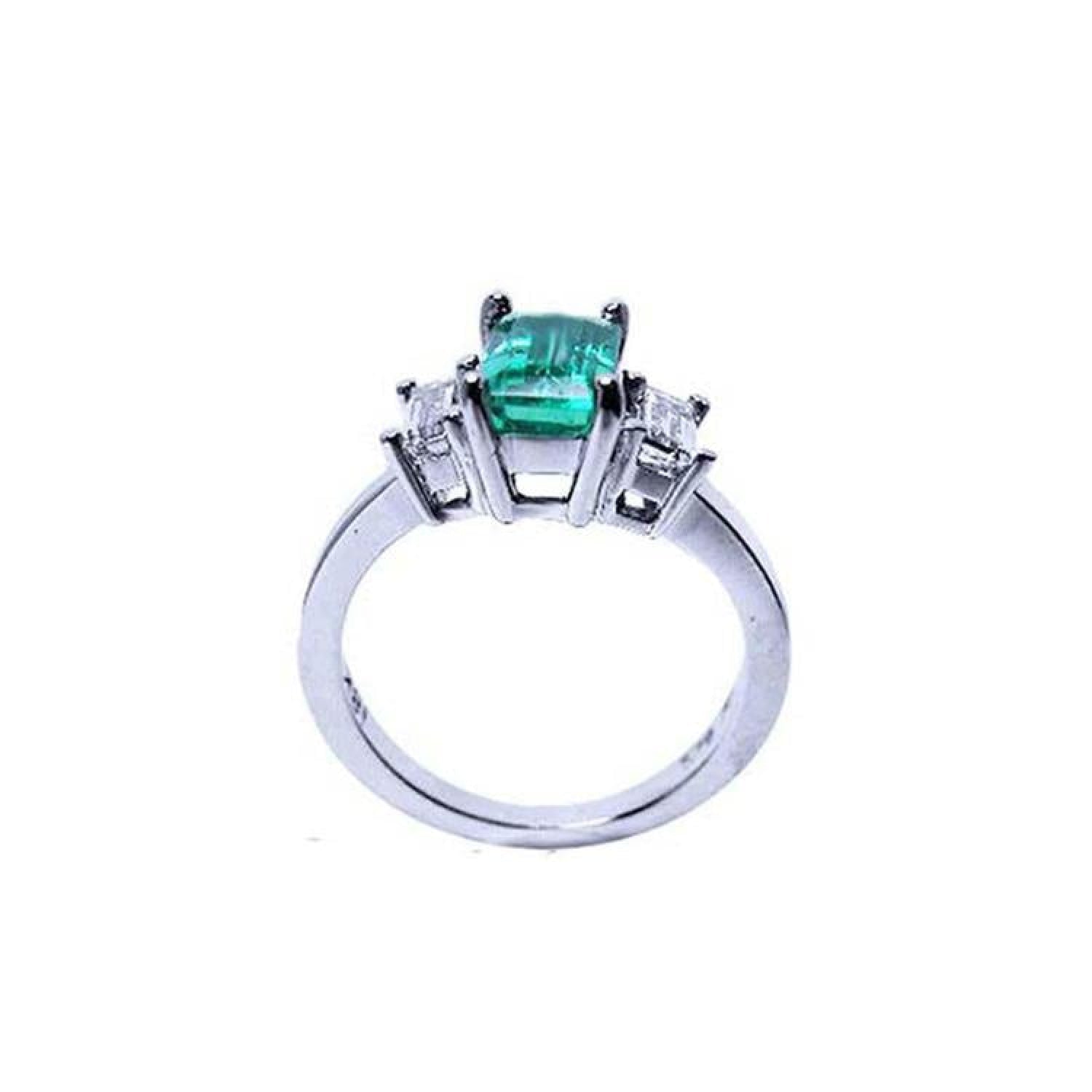 Emerald cut three stone ring with medium bluish green emerald and side baguette diamonds in 18K white gold.