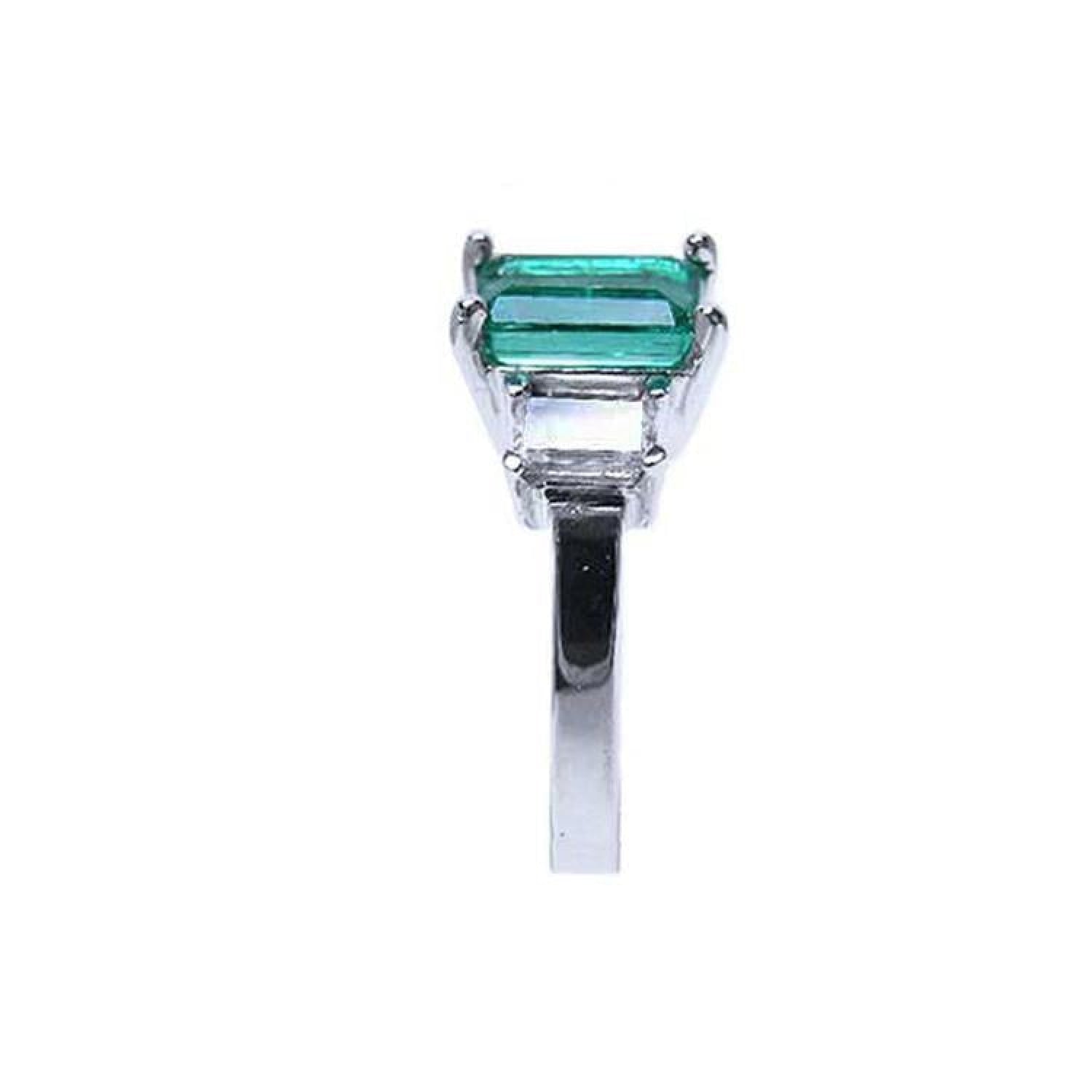 Emerald cut three stone emerald ring with baguette diamonds in 18K white gold.