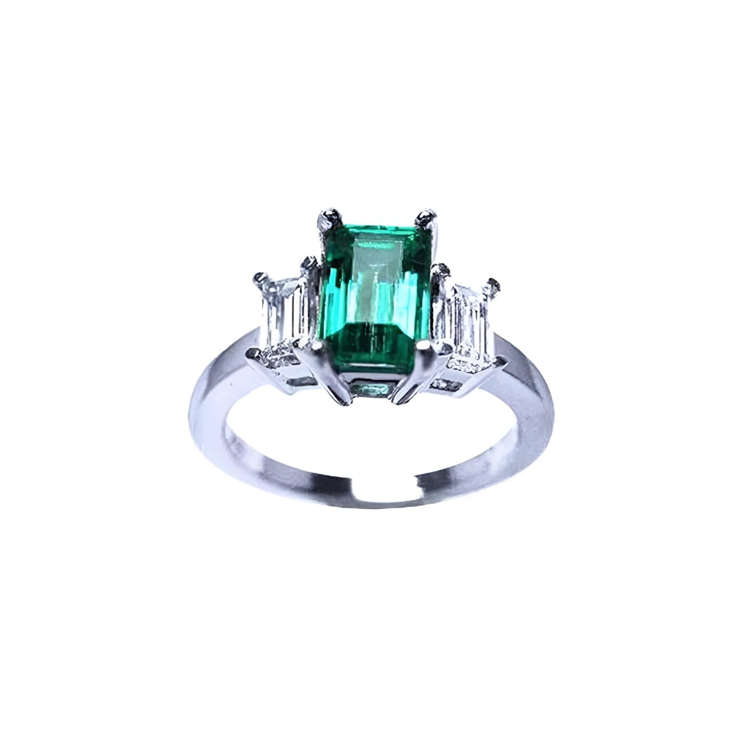 Emerald cut three stone ring with a medium bluish-green emerald and baguette diamonds in 18K white gold.