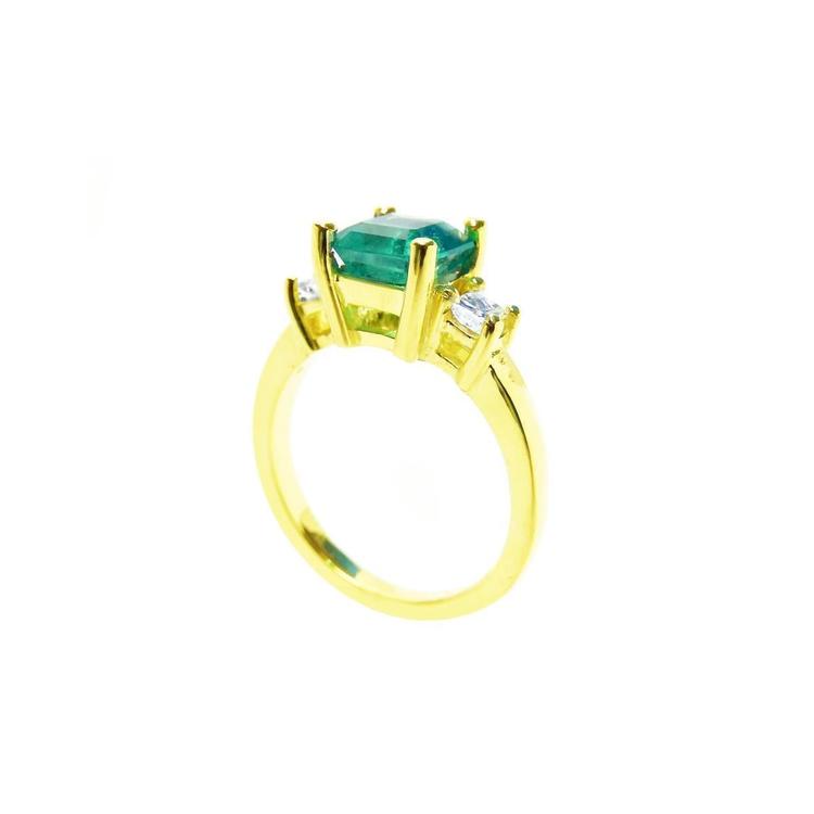 18K yellow gold three-stone ring with a square emerald and princess-cut side diamonds.