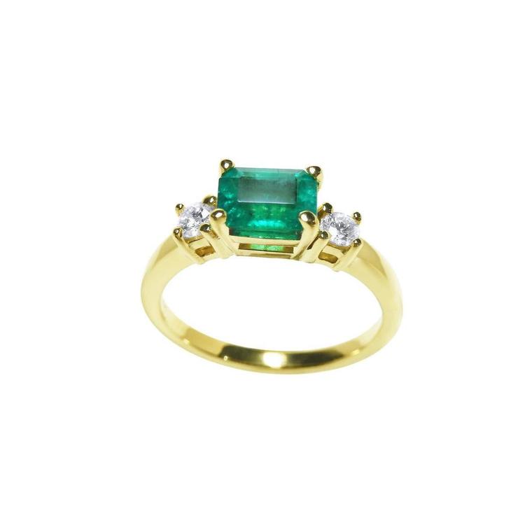 1.01 ct rectangular emerald ring with two round natural diamonds set in 14K yellow gold.