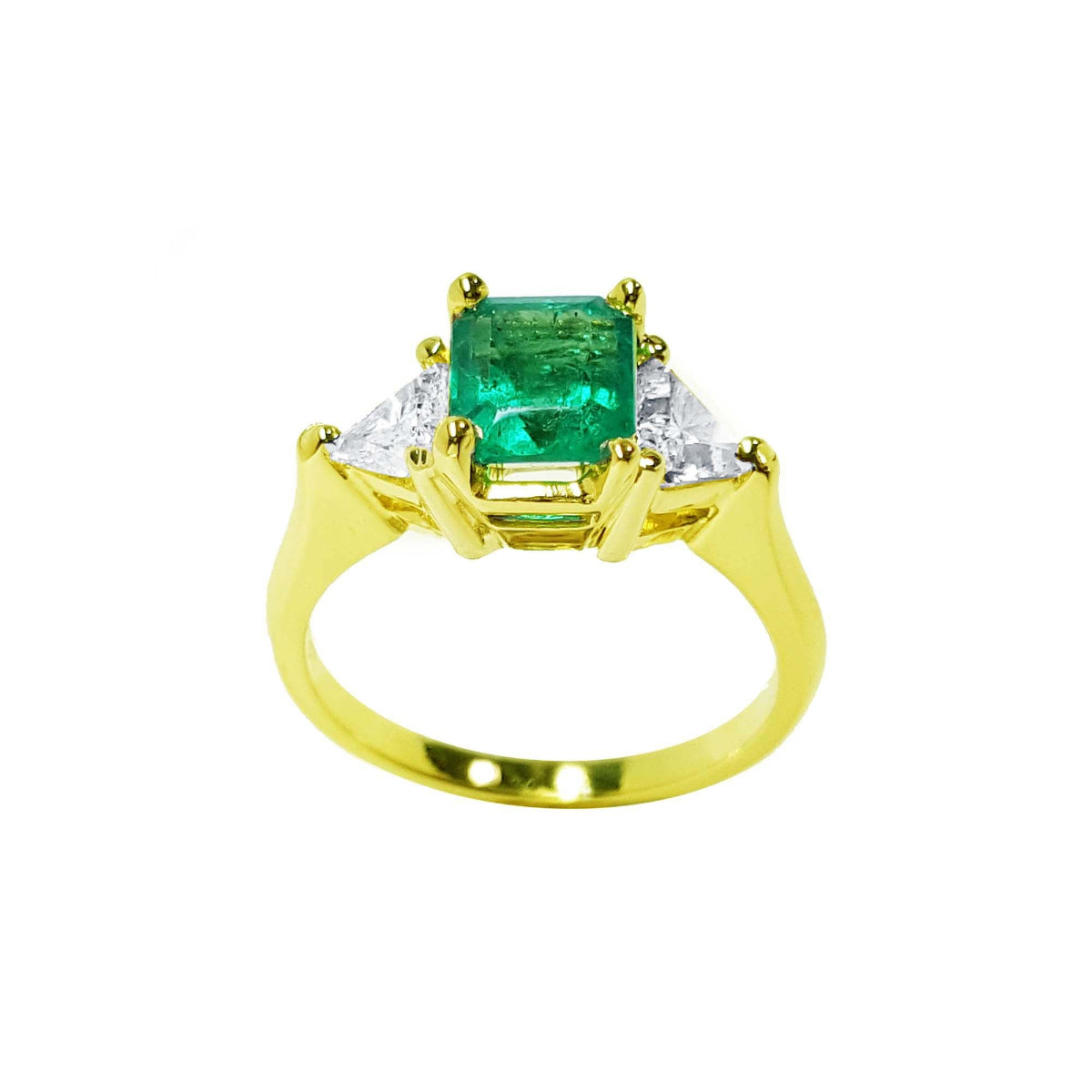 A center natural colombian emerald ring for women, flanked by trillion cut diamonds in 18 yellow gold.