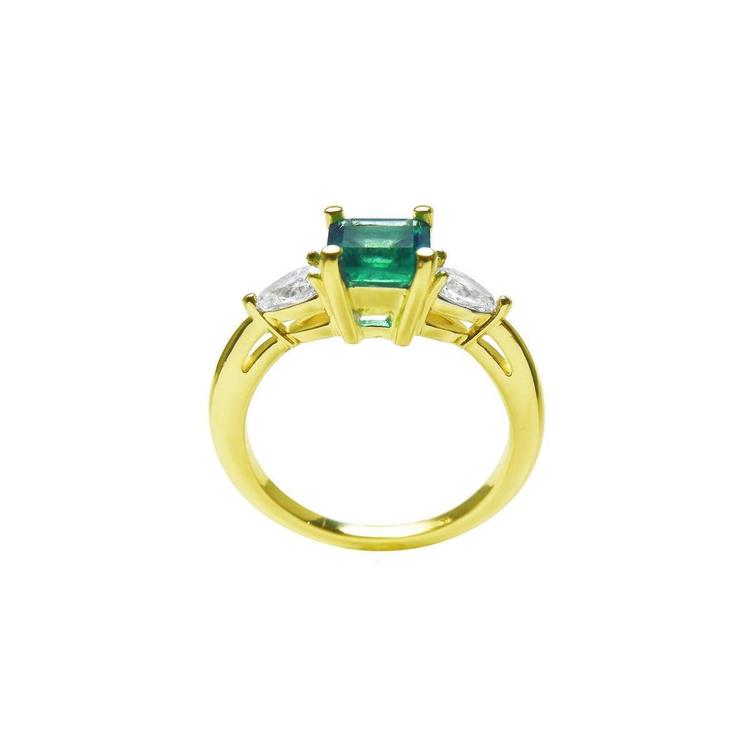 14K yellow gold three-stone ring with a vibrant emerald and two pear-shaped diamonds.