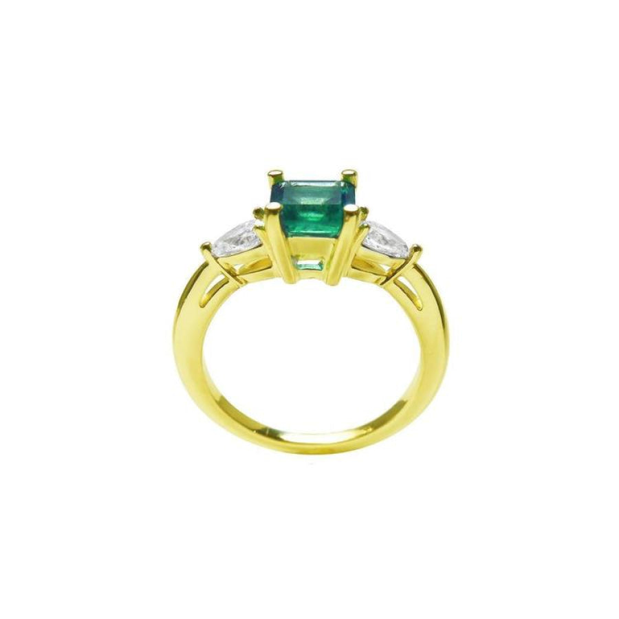 14K yellow gold three-stone ring with a vibrant emerald and two pear-shaped diamonds.