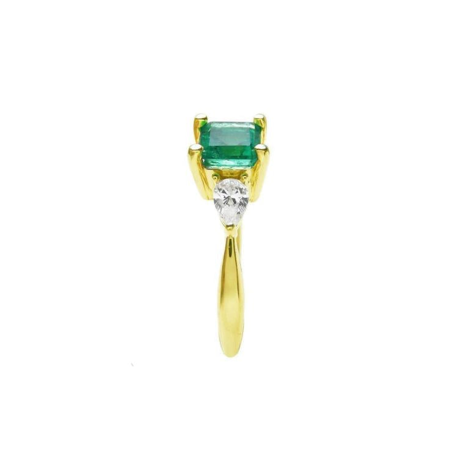 14K yellow gold three-stone ring with a vibrant emerald and two pear-shaped diamonds.