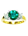 This round cut emerald ring side diamonds three stone displays the top side profile. 