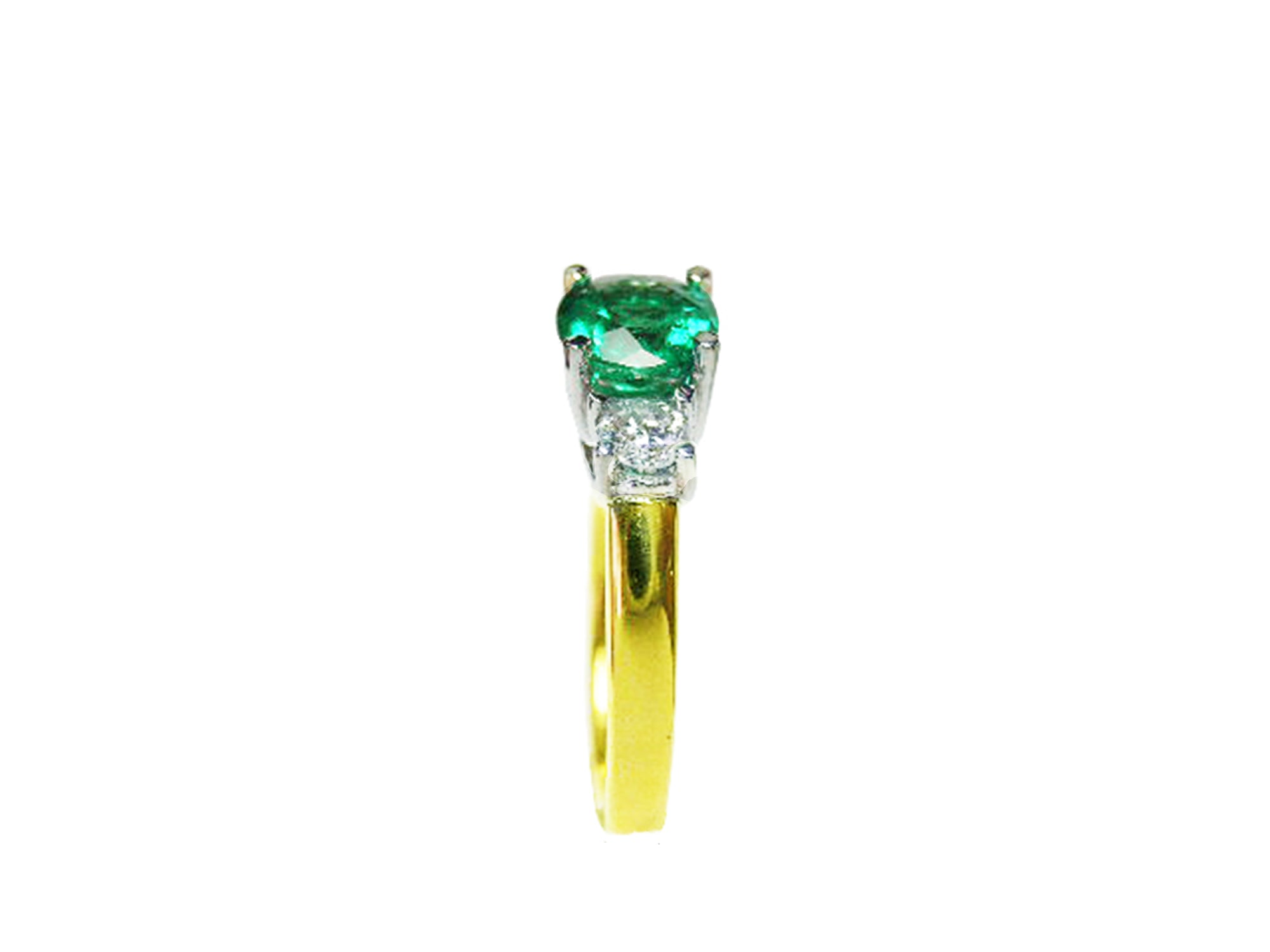 A side profile of this gold ring with a round emerald and smaller diamonds on a white background.