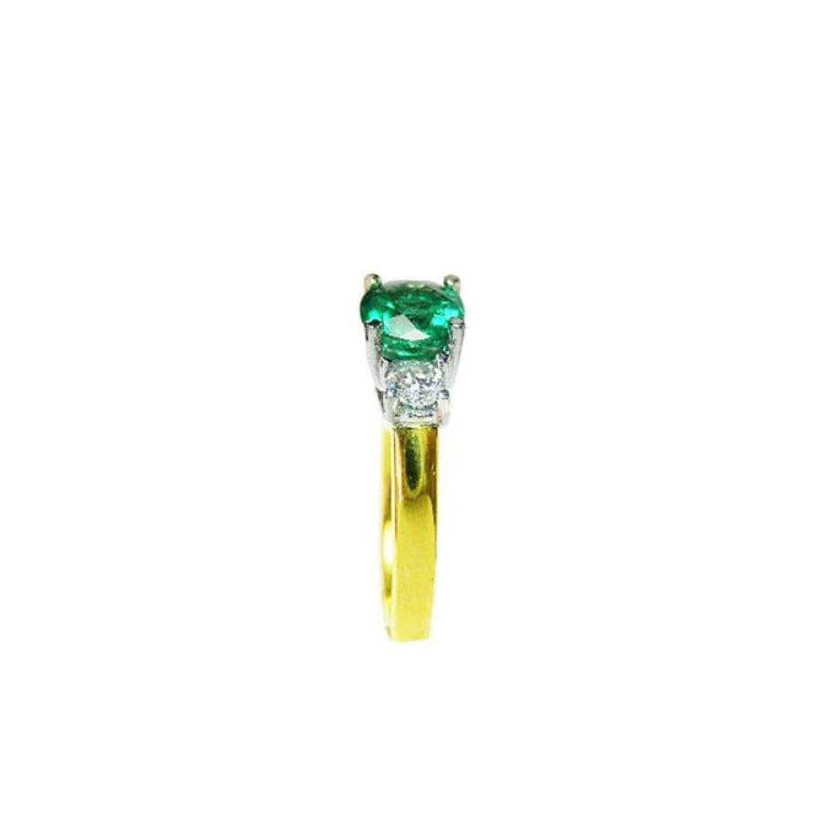 1.12 ct. round cut three stone emerald and diamond ring in 14k white and yellow gold.