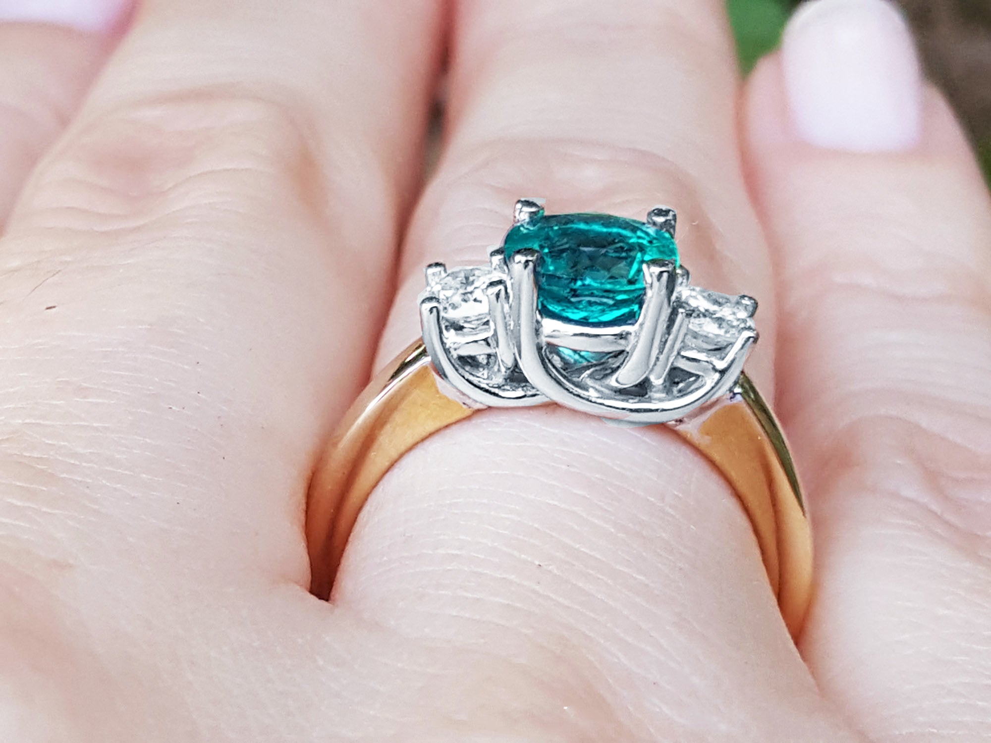 Mother&#39;s Day gift three stone emerald ring on a hand.