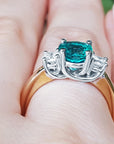 Mother's Day gift three stone emerald ring on a hand.