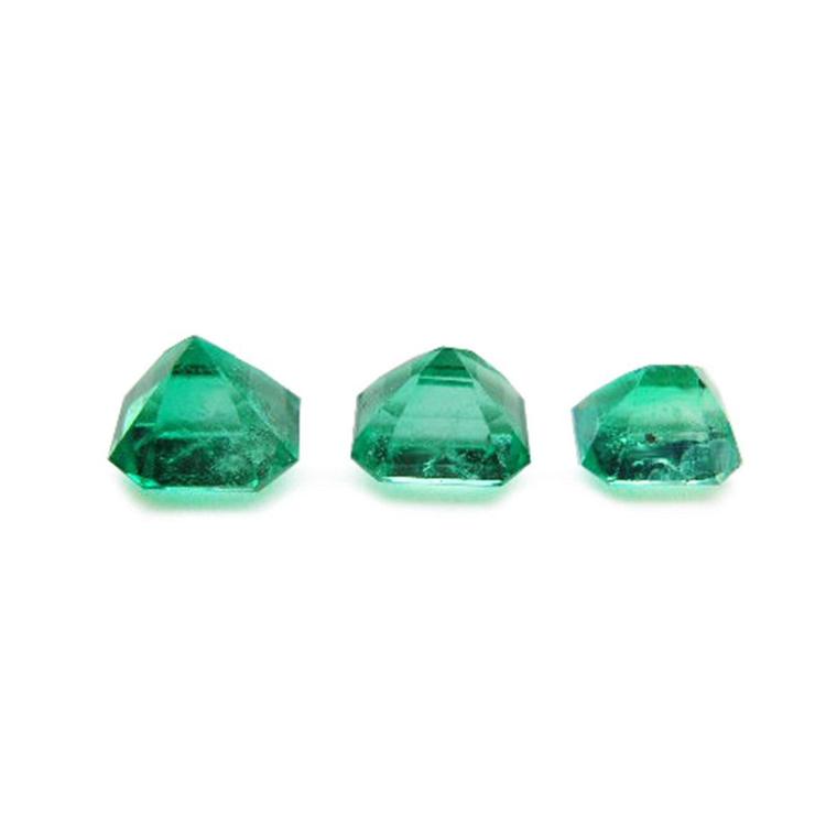 Three emerald-cut natural Colombian emeralds, a matched set for jewelry, on a white background.