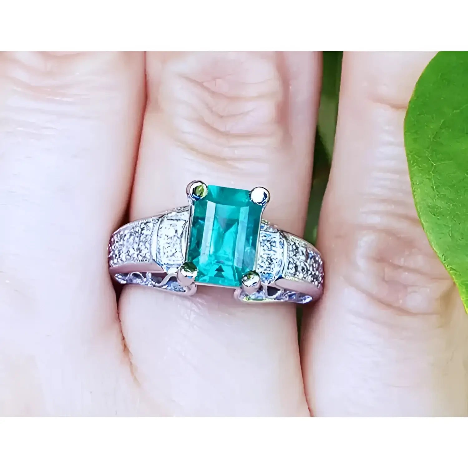 imagen cercana de un anillo para mujer con esmeralda y diamants hecho en oro blanco.