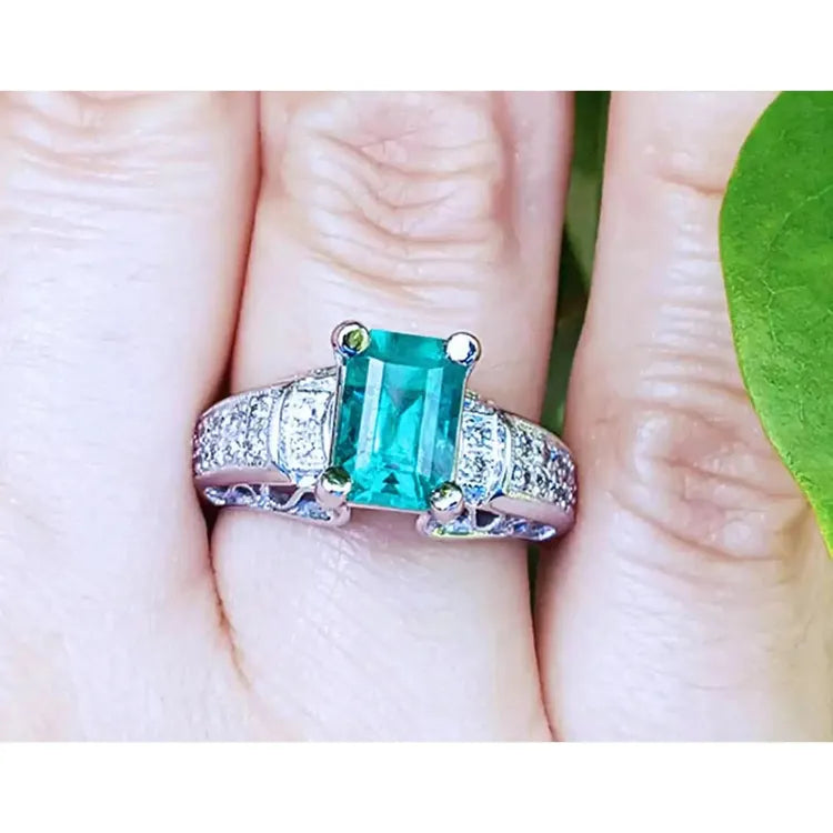 imagen cercana de un anillo para mujer con esmeralda y diamants hecho en oro blanco.