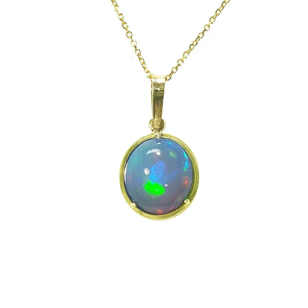 Opal pendant necklace on a gold chain on topside position against a white background