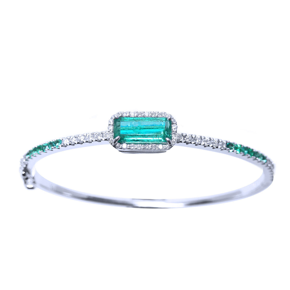 
The topside view of a bangle bracelet with natural colombian emeralds and diamonds in white gold.