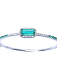 
The topside view of a bangle bracelet with natural colombian emeralds and diamonds in white gold.