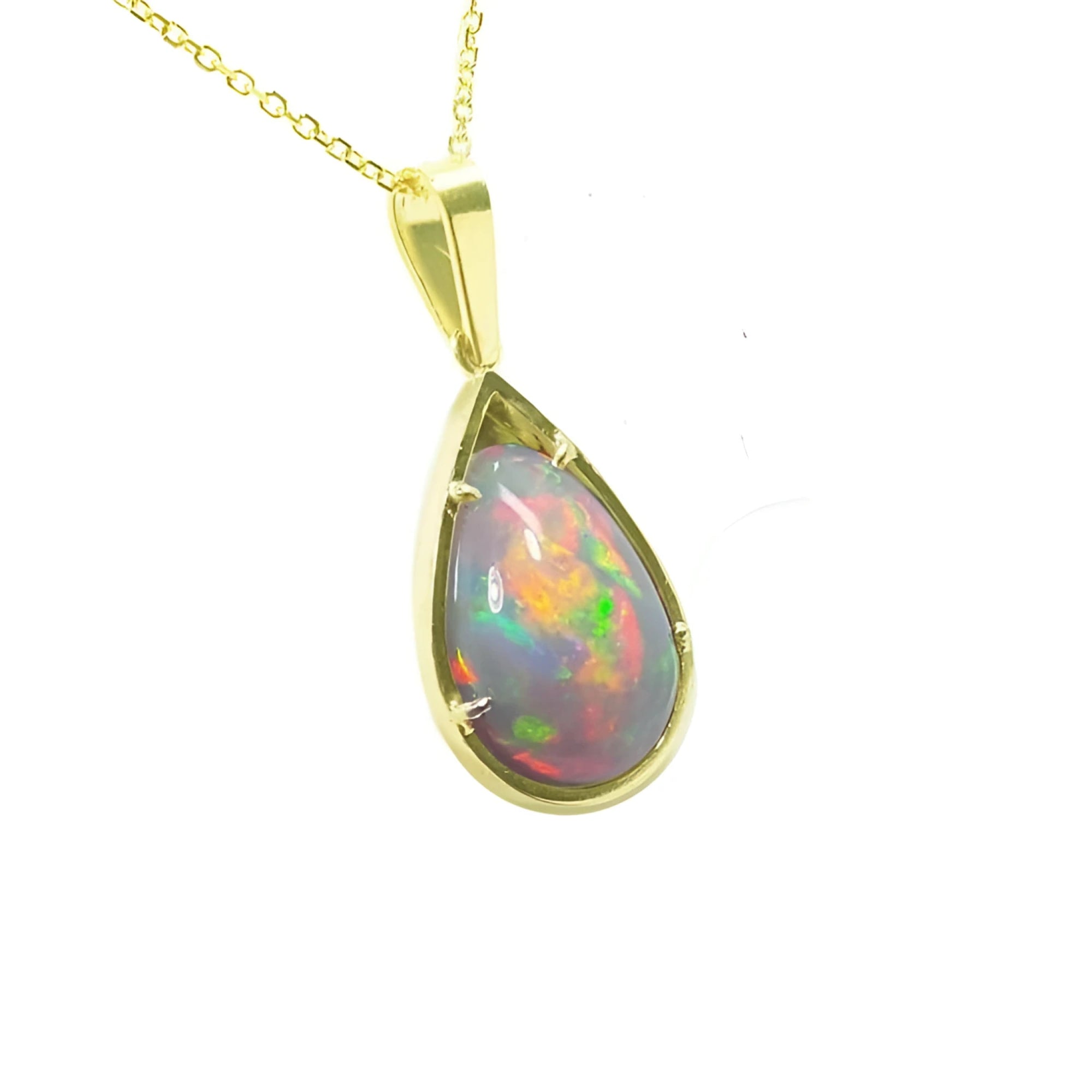 Pear-shaped Ethiopian Welo opal pendant with red-orange fire and rainbow colors, prong set in 14K yellow gold.