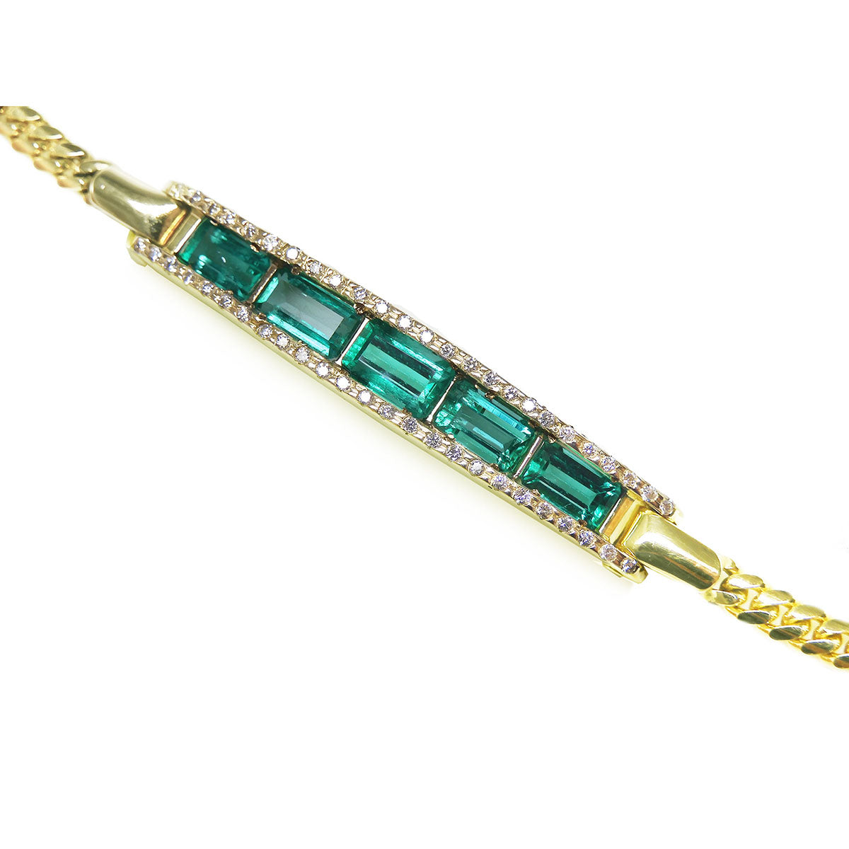 Gold bracelet with five natural colombian emeralds and diamonds on a topside view.