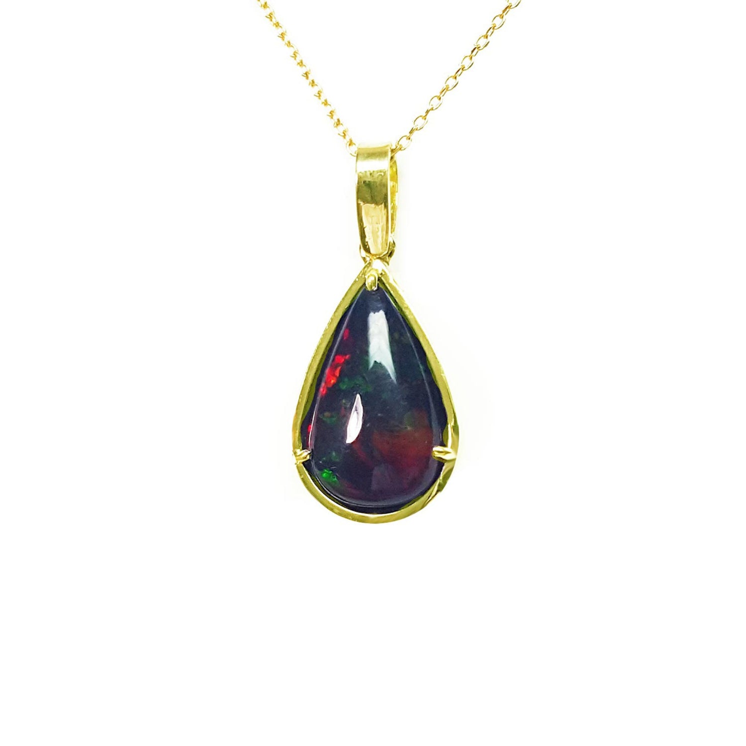 Teardrop-shaped black opal pendant on a gold chain on topside view against a white background.